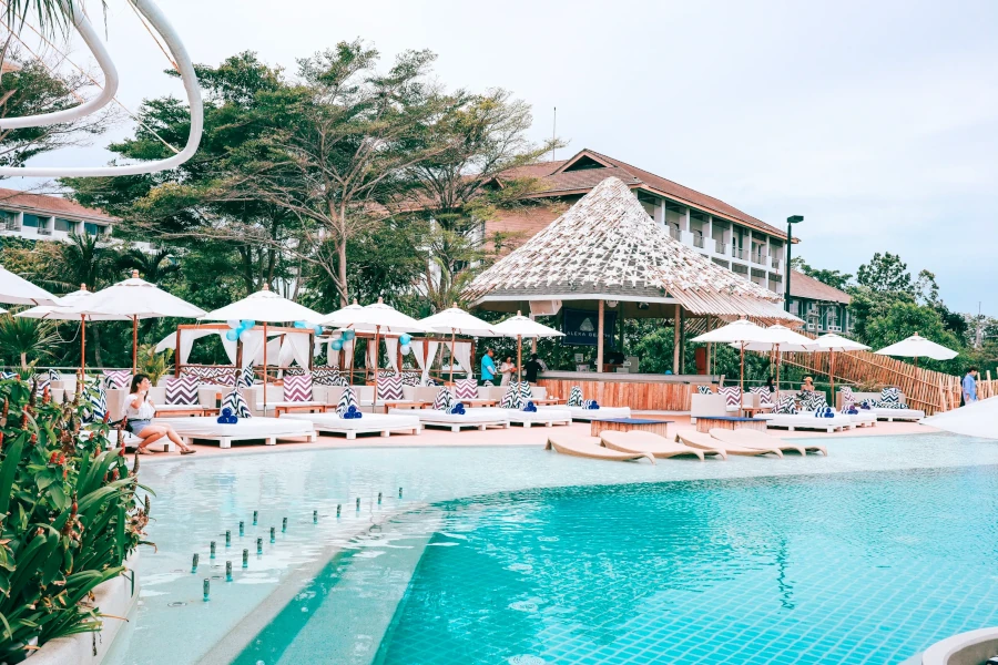 Stunning outdoor pool area at Alexa Beach Club Pattaya, surrounded by lush greenery and chic lounge spaces.