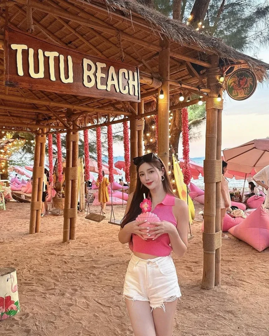Captivating image of a stylishly dressed young woman striking a pose with a cocktail at Tutu Beach Club Pattaya.