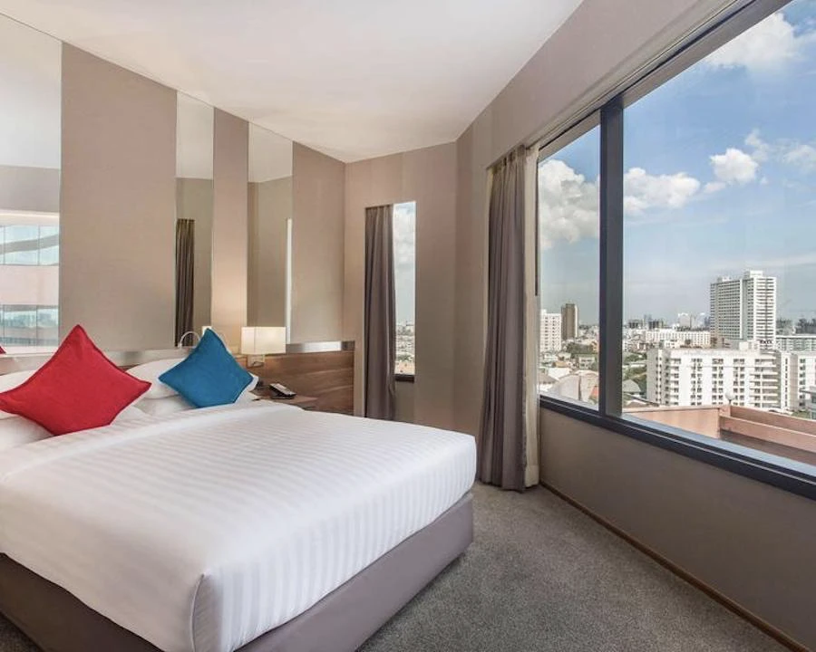 hotel room displaying a bed with view of bangkok from swissôtel