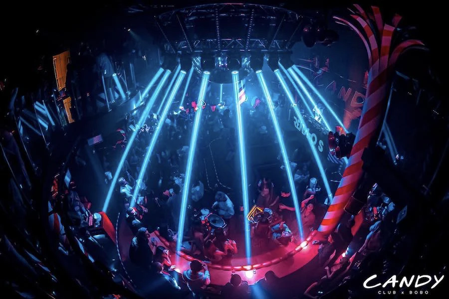 view of candy club with neon lights and people dancing