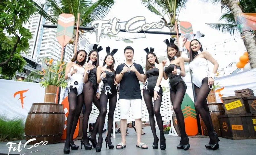 man surrounded by Thai Playmates at a corporate party in Pattaya