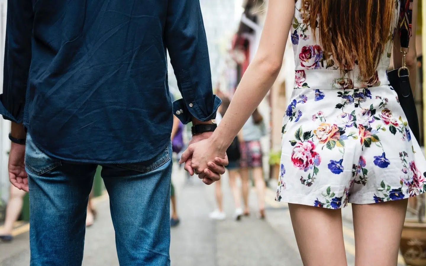 couple holding hands in the street