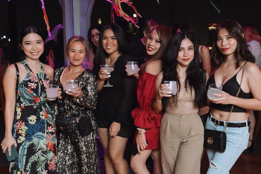 cute Thai girls holding glasses at Above Eleven rooftop bar in Bangkok