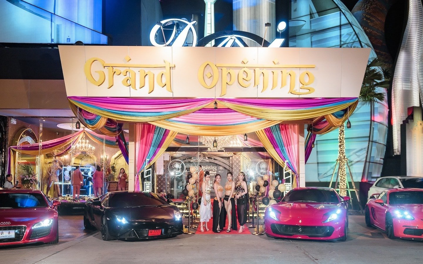 entrance of Dubai Luxury Club in Bangkok with luxury cars and beautiful Thai models