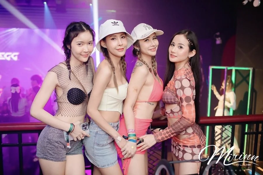 four Thai girls posing at mirinn club in Bangkok during an event while partying