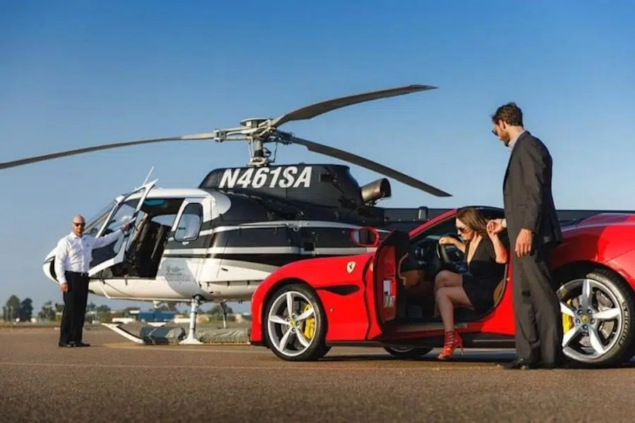 models getting out of ferrari and going to their helicopter
