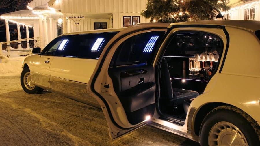 white stretch limousine with an open door and drinks and champagne inside