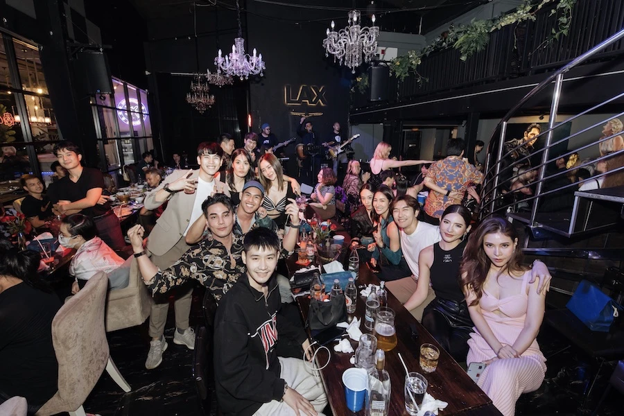 a shot of a table packed with a large group of friends eating and drinking at lax rca restaurant