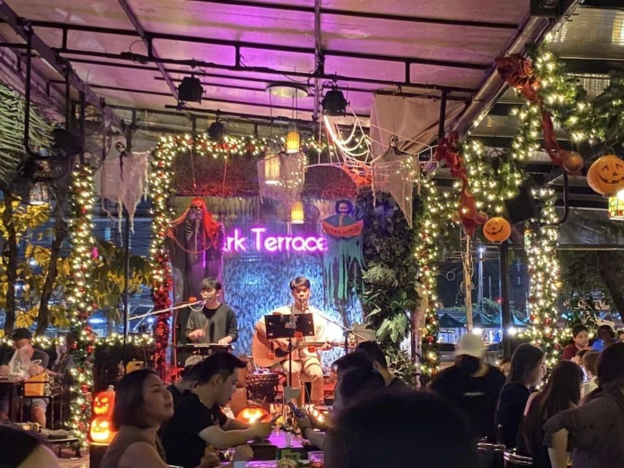 people enjoying dinner, drinks and a live band at play ratchada in bangkok