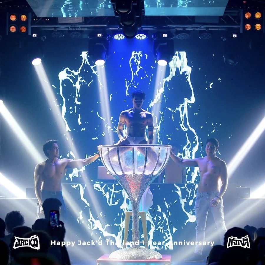 muscular men on a stage at fake club in bangkok, one man is in a giant cup dancing