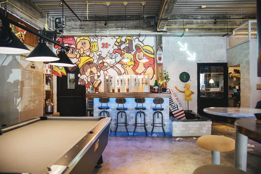 interior of nineteens up bar displaying a pool table and beer taps on the decorated wall in bangkok