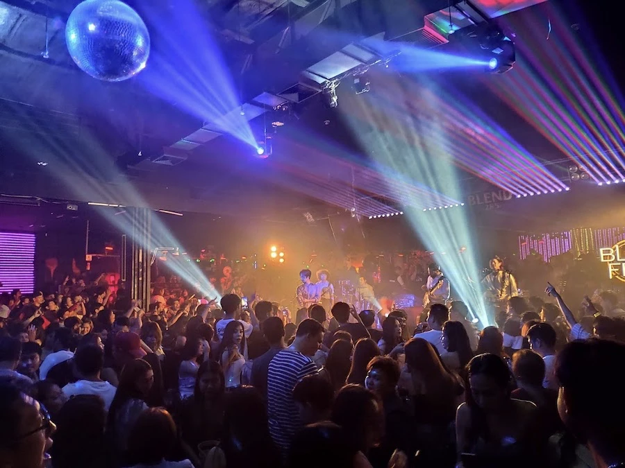 a crowd is dancing during a live event at snop club in bangkok