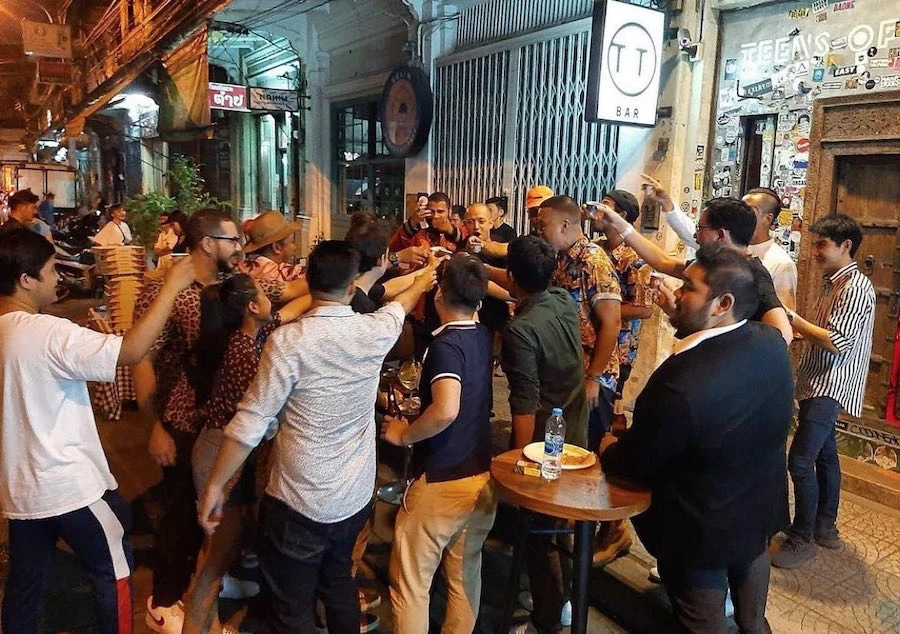 people drinking in the street in front of Teens of Thailand cocktail bar in Bangkok