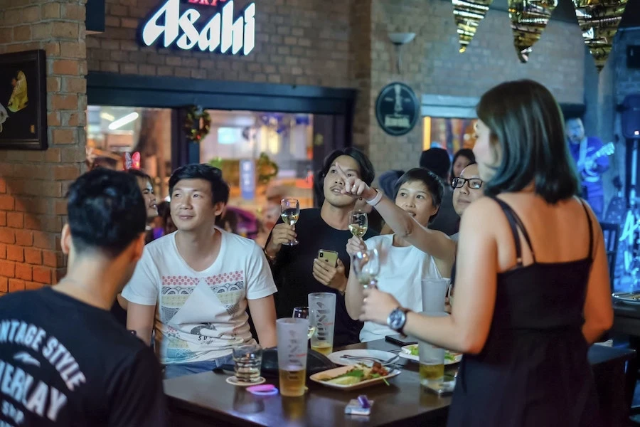 a group of friends chilling and drinking draft beer and white wine in ekamai beer house bar