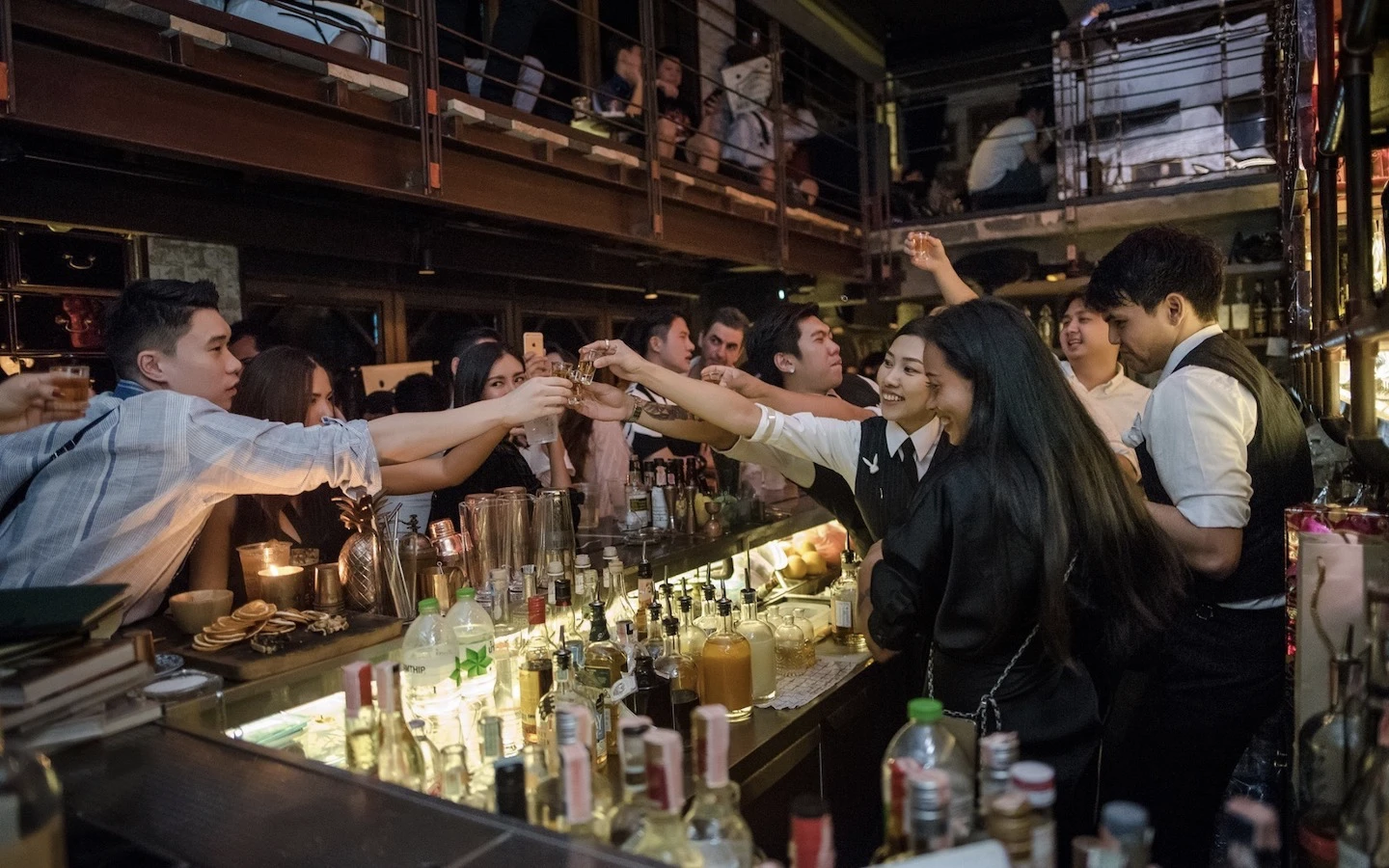 bartenders sharing shots of alcohol with clients at Rabbit hole bar in Bangkok