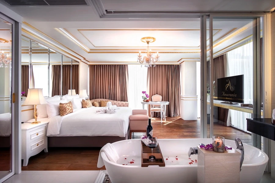 view of a bedroom at amaranta hotel bangkok displaying a beautiful bathtub and a king size bed
