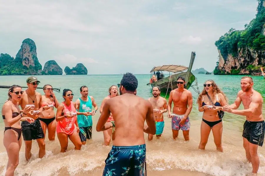 people drinking beers on the beach before a boat party in Krabi organized by Slumber Party Hostel
