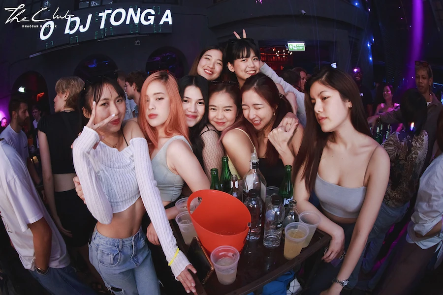 a large group of Thai girls around a small table partying at the club khaosan in khaosan road in bangkok
