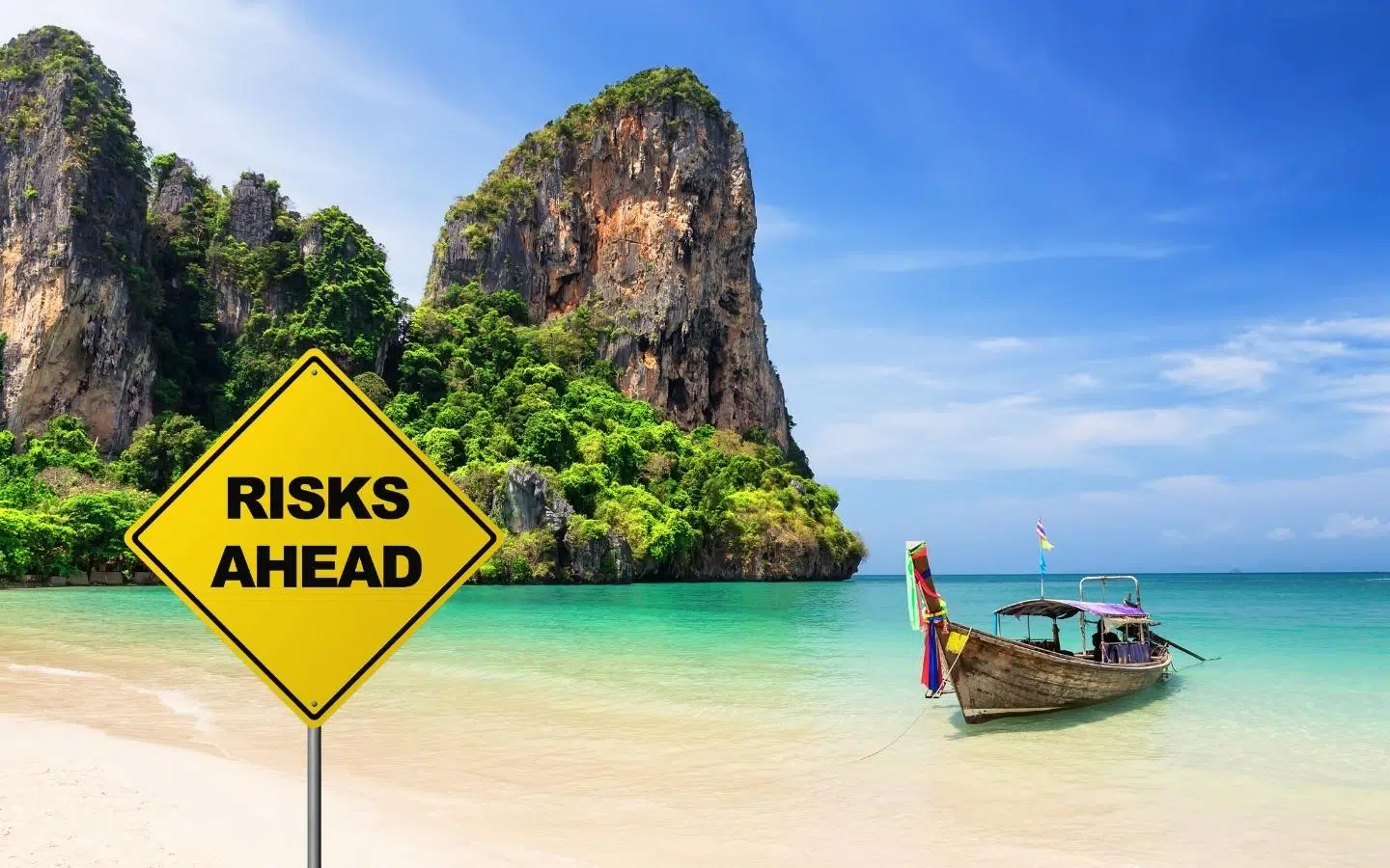 risks ahead sign on a beautiful Thai beach with a longtail boat
