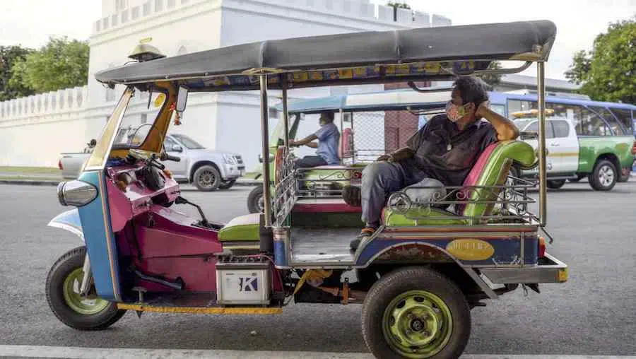driver chilling at the back of his tuk tuk in Bangkok Thailand