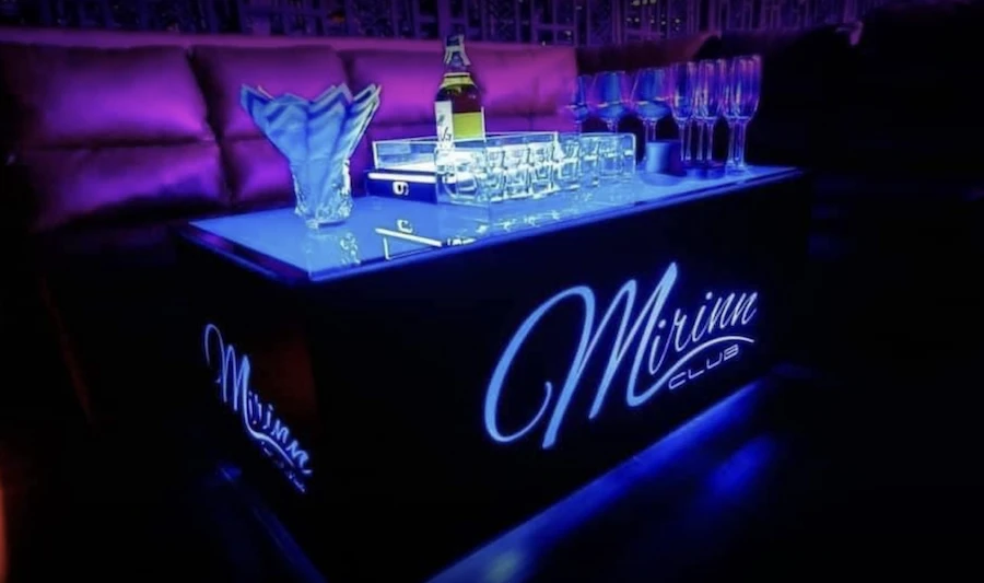 a table from VIP corner at mirinn club Bangkok displaying a bottle and a set of glasses