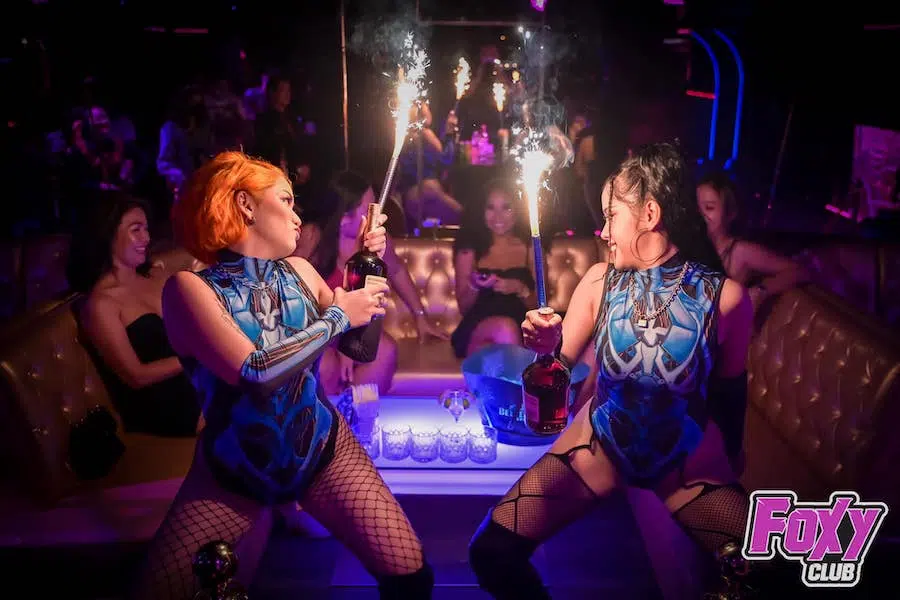 dancers holding bottles with flares at a VIP table at Foxy Club Bangkok