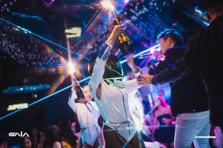 a waitress with a white body and a helmet takes a bottle of champagne to gaia bangkok