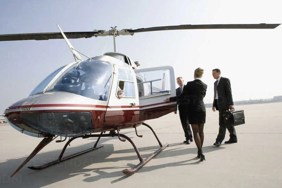 women walking two business men to their helicopter charter