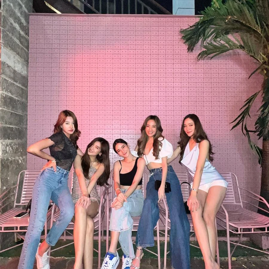 five pretty thai girls standing in front of famous cassette pink wall
